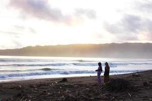 indonesia 2021. una coppia che gioca sulla spiaggia all'ora del tramonto foto