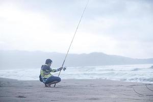 pacitan, indonesia 2021 - uomo che pesca sulla costa foto