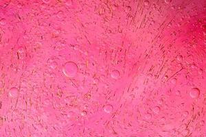 foto di olio su una superficie d'acqua con bolle.rosa tenue. sfondo colorato astratto.