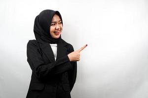 bella giovane donna d'affari musulmana asiatica con le mani che puntano lo spazio vuoto presentando qualcosa, sorridente fiducioso, entusiasta, allegro, di fronte allo spazio vuoto, isolato su sfondo bianco