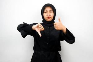 Bella asiatica giovane donna musulmana con segno di mano come o antipatia, sì o no, felice o triste, confrontando due cose, isolato su sfondo bianco