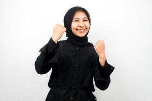 bella giovane donna musulmana asiatica sorridente sicura di sé, entusiasta e allegra con le mani serrate, segno di successo, pugni, combattimenti, non paura, isolato su sfondo bianco