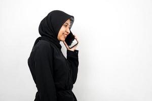 bella giovane donna musulmana asiatica sorridente con fiducia e allegramente chiamando qualcuno, di fronte a uno spazio vuoto, isolato su sfondo bianco, concetto pubblicitario