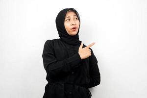 bella giovane donna musulmana asiatica scioccata, sorpresa, espressione wow, con la mano che indica lo spazio vuoto, presentando qualcosa, presentando il prodotto, isolato su sfondo bianco foto