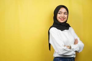 bella giovane donna musulmana asiatica sicura e allegra che sembra uno spazio vuoto che presenta qualcosa, isolato su sfondo giallo