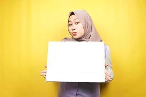 bella giovane donna musulmana scioccata, sorpresa, wow, mano che tiene striscione vuoto vuoto, cartello, lavagna bianca, cartello bianco, cartellone pubblicitario bianco, presentando qualcosa nello spazio della copia, promozione
