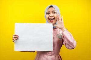bella giovane donna musulmana allegra con striscione vuoto vuoto, cartello, lavagna bianca, cartello bianco, cartellone pubblicitario bianco, presentando qualcosa nello spazio della copia, promozione