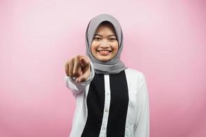 bella giovane donna musulmana asiatica con le mani che puntano alla telecamera, desiderandoti, indicandoti, volendo stare con te, sorridente sicura, entusiasta e allegra, di fronte alla telecamera, isolata
