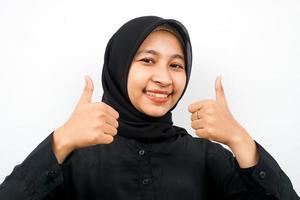 primo piano di bella giovane donna musulmana con il pollice in alto la mano, buon lavoro, vittoria, isolata foto