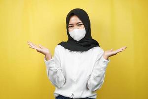 donna musulmana che sorride con sicurezza con i palmi aperti, presentando qualcosa, presentando un prodotto, isolato su sfondo giallo