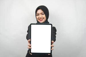 bella giovane donna d'affari musulmana asiatica sicura e sorridente, mani che tengono tablet con schermo bianco o schermo vuoto, presentando qualcosa, presentando il prodotto, presentando il rapporto, isolato foto