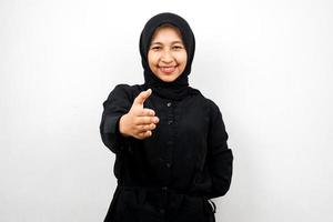 bella giovane donna musulmana asiatica sorridente con fiducia, con le mani che stringono la macchina fotografica, segno di cooperazione con le mani, segno di accordo con la mano, segno di amicizia con la mano, isolato su sfondo bianco