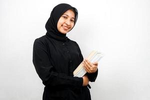 bella giovane donna musulmana asiatica che porta un libro isolato foto