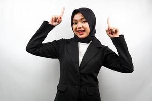 bella giovane donna d'affari musulmana asiatica sorridente sicura di sé, entusiasta e allegra con le mani rivolte verso l'alto presentando qualcosa, guardando la telecamera isolata su sfondo bianco