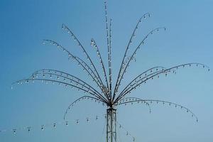 molte lampadine decorate sui rami d'acciaio a forma di fiore per il festival locale in thailandia isolato su sfondo blu cielo foto