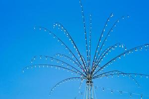 molte lampadine decorate sui rami d'acciaio a forma di fiore per il festival locale in thailandia isolato su sfondo blu cielo foto