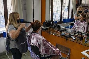parrucchiere latino. il parrucchiere asciuga i capelli del suo cliente. foto