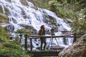 donna asiatica viaggio relax per fotografare le belle cascate. in inverno. alla cascata mae ya chiangmai in thailandia. natura di viaggio. estate foto