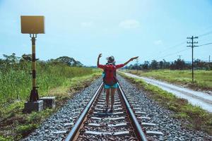 le donne asiatiche viaggiano in campagna. viaggiare rilassati. borsa zaino da viaggio. camminare sulla ferrovia. Tailandia foto