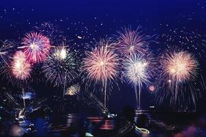 sfondo festivo capodanno con fuochi d'artificio e bokeh. fuochi d'artificio di capodanno sulla spiaggia.