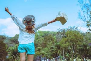 natura di viaggio donna asiatica. viaggiare rilassati. libro di lettura sul nel parco. in estate. foto