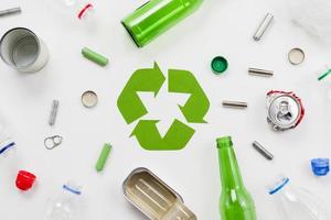 emblema del riciclaggio attorno a diversi rifiuti foto