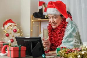 donna asiatica che tosta champagne festeggia il capodanno e la festa di Natale videochiama gli amici a casa
