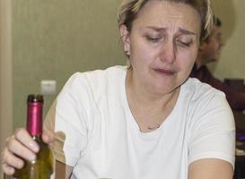 una donna sposata piange e beve alcolici. alcolismo femminile.messa a fuoco selettiva. grana della pellicola. foto
