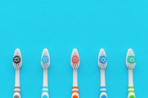 spazzolini da denti multicolori su sfondo blu. la vista dall'alto. avvicinamento.
