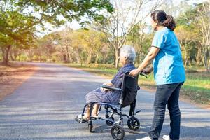 medico aiuto e cura asiatico anziano o anziana signora anziana paziente seduta su sedia a rotelle al parco nel reparto ospedaliero di cura, concetto medico sano e forte. foto