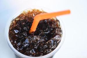caffè nero con ghiaccio nel bicchiere di plastica - primo piano caffè freddo