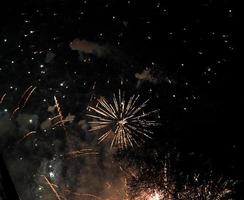 scoppiano fuochi d'artificio colorati nel cielo notturno scuro foto