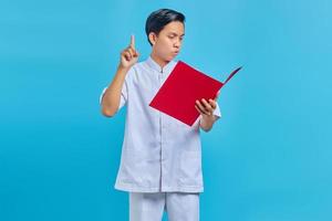 pensieroso infermiere che punta il dito contro la cartella su sfondo blu foto