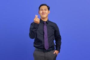 sorridente giovane uomo asiatico che mostra gesto di amore segno su sfondo viola