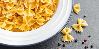 Farfalle pasta cruda fiocchi di grano duro farina sana foto