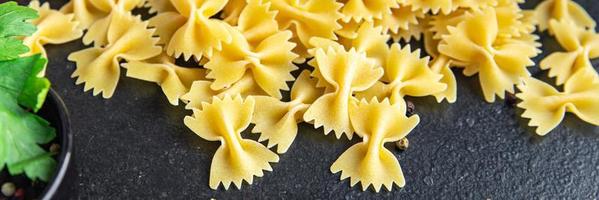 Farfalle pasta cruda fiocchi di grano duro farina sana foto