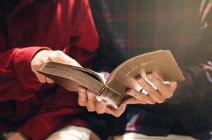 una donna e due uomini stavano studiando e leggendo la Bibbia. questo è amore cristiano foto