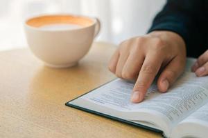 una giovane donna cristiana si siede a casa a leggere e studiare la Bibbia la domenica. con la dottrina del santo profeta foto