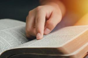 una giovane donna che indica i versetti delle Scritture che sono veritieri. mentre leggevo la Bibbia al mattino vicino al davanzale della finestra foto