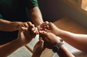 un gruppo di giovani che si tengono per mano in preghiera secondo la fede di Dio nel cristianesimo