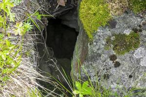 buco nella roccia tra pietre con muschio in norvegia. foto