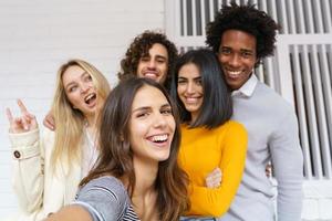 gruppo multietnico di amici che si fanno un selfie insieme divertendosi all'aperto. foto