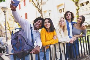 gruppo multietnico di amici che si fanno un selfie in strada con uno smartphone. foto