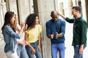 gruppo multietnico di amici che si divertono insieme all'aperto foto