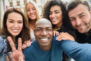 gruppo multirazziale di giovani che si fanno selfie foto