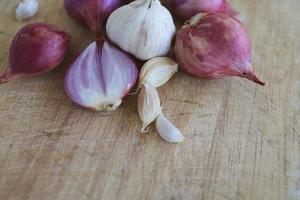 cipolla e aglio per cucinare su fondo in legno vecchio foto