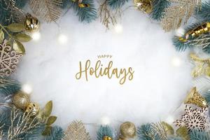 Buone vacanze testo con cornice fatta di decorazioni natalizie distese su sfondo innevato foto