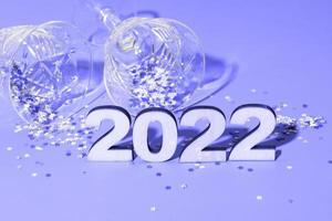 festivo capodanno piatto con numeri 2022 e ombre dure con occhiali e decorazioni lucide foto