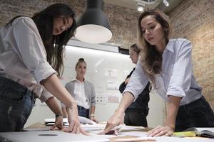 il team dei colleghi e il collega hanno fatto un brainstorming, discutendo una strategia di marketing, la collaborazione di idee e la pianificazione di progetti aziendali al tavolo da conferenza di un ufficio nel luogo di lavoro della riunione del personale. foto