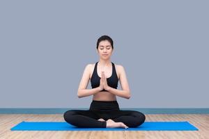 la donna asiatica mantiene la calma e medita mentre pratica lo yoga per esplorare la pace interiore. lo yoga e la meditazione hanno buoni benefici per la salute. concetto di foto per lo sport e uno stile di vita sano.
